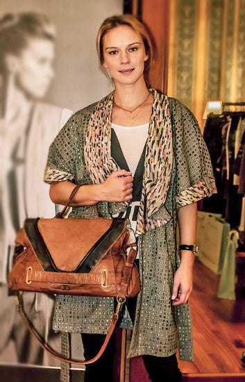Antonia Liskova wears light coat and leather bag by Chiara Baschieri